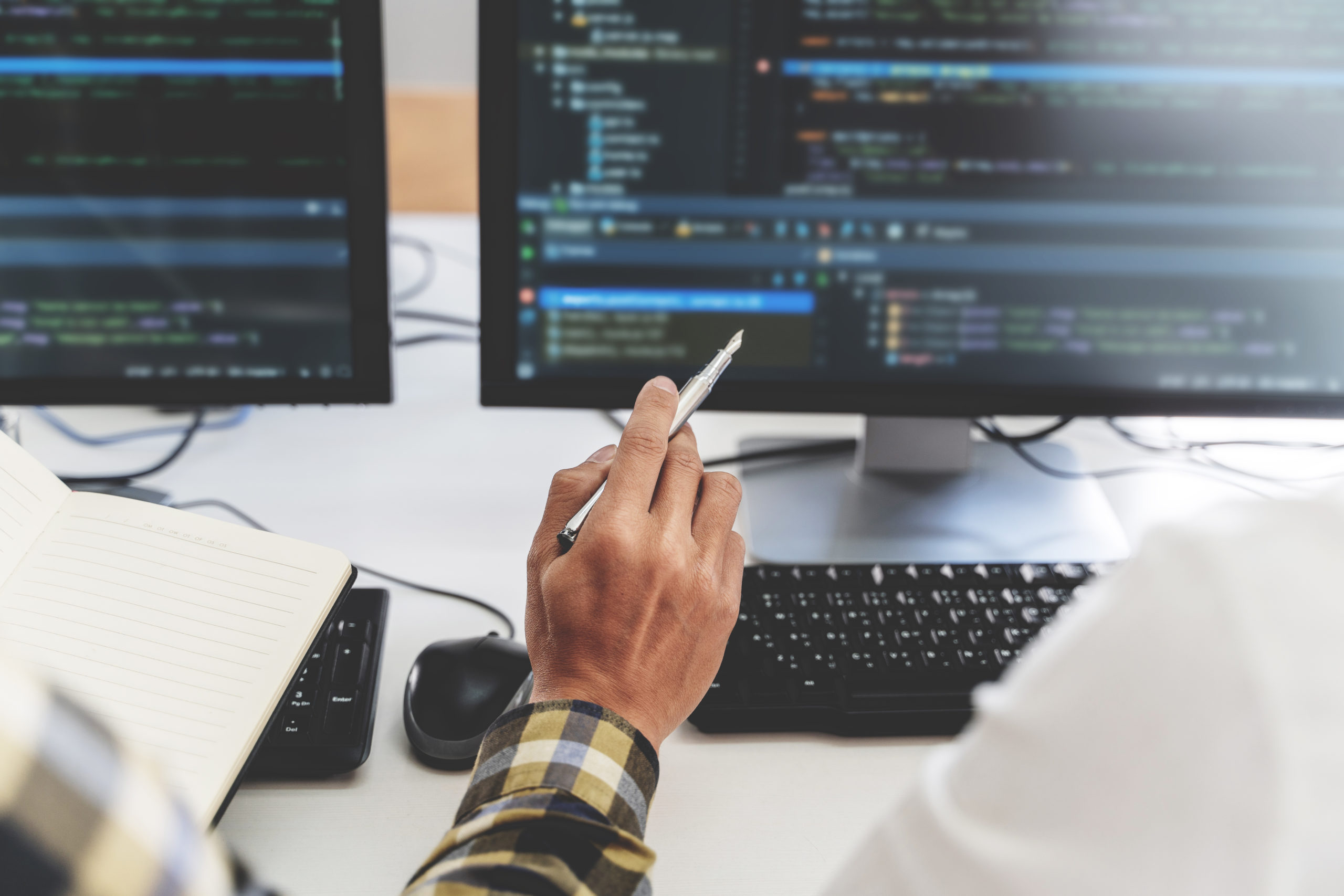 Feature Image for Azure Traffic Manager for Developers. Image of a developer sitting at a computer with lines of code across the screen