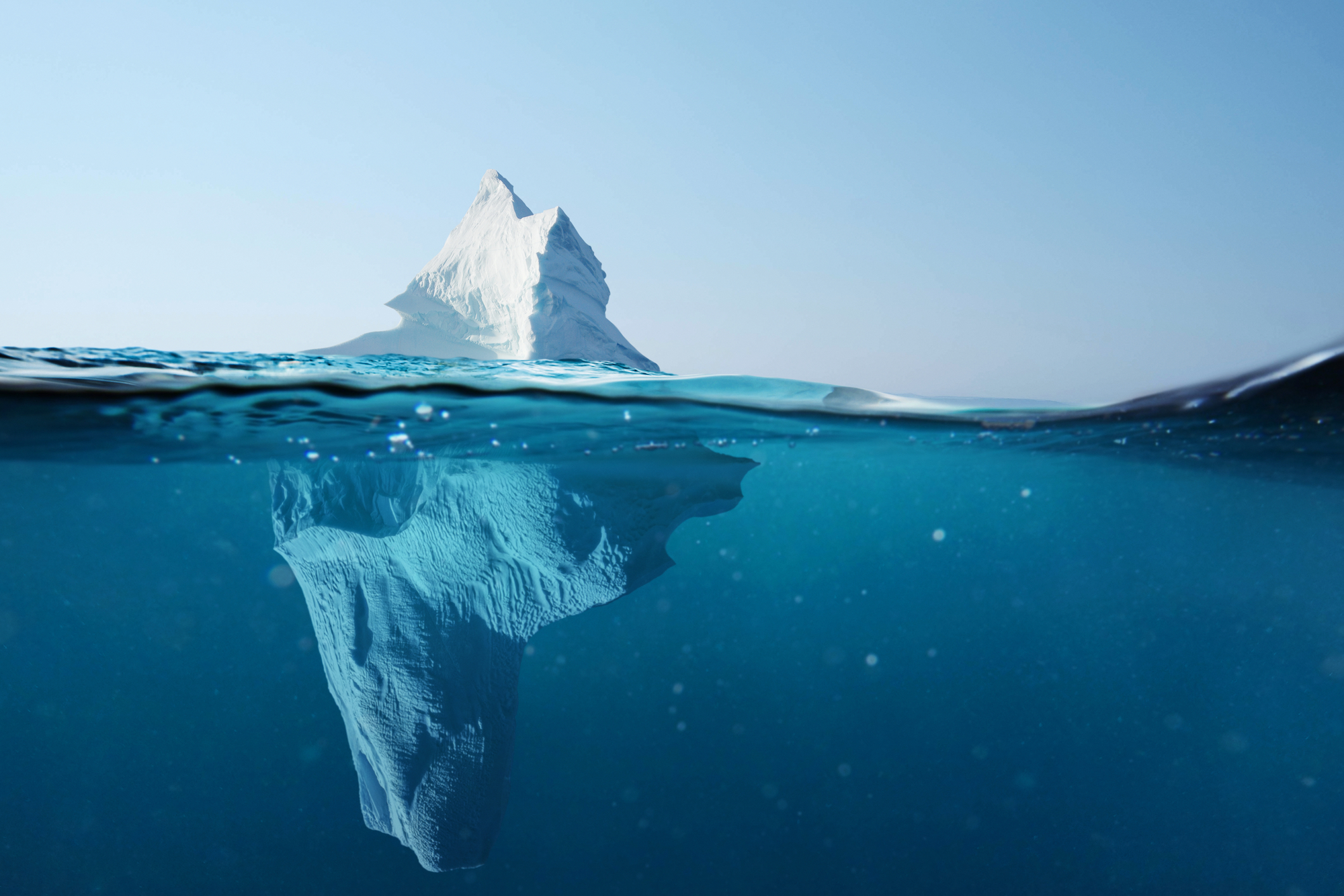 Feature Image: Hidden Benefits of Azure Cloud Migration. Image: An iceberg that is much larger under the surface of the water than what is visible above the water.