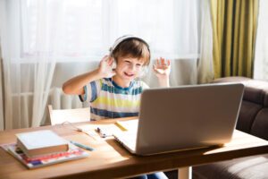 Image of a young child doing online schooling. Read how to keep your kids safe online with this blog post
