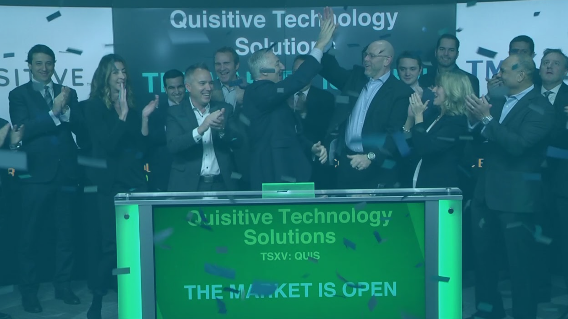 Image of many people cheering with confetti and sign that reads Quisitive Technology Solutions The Market Is Open