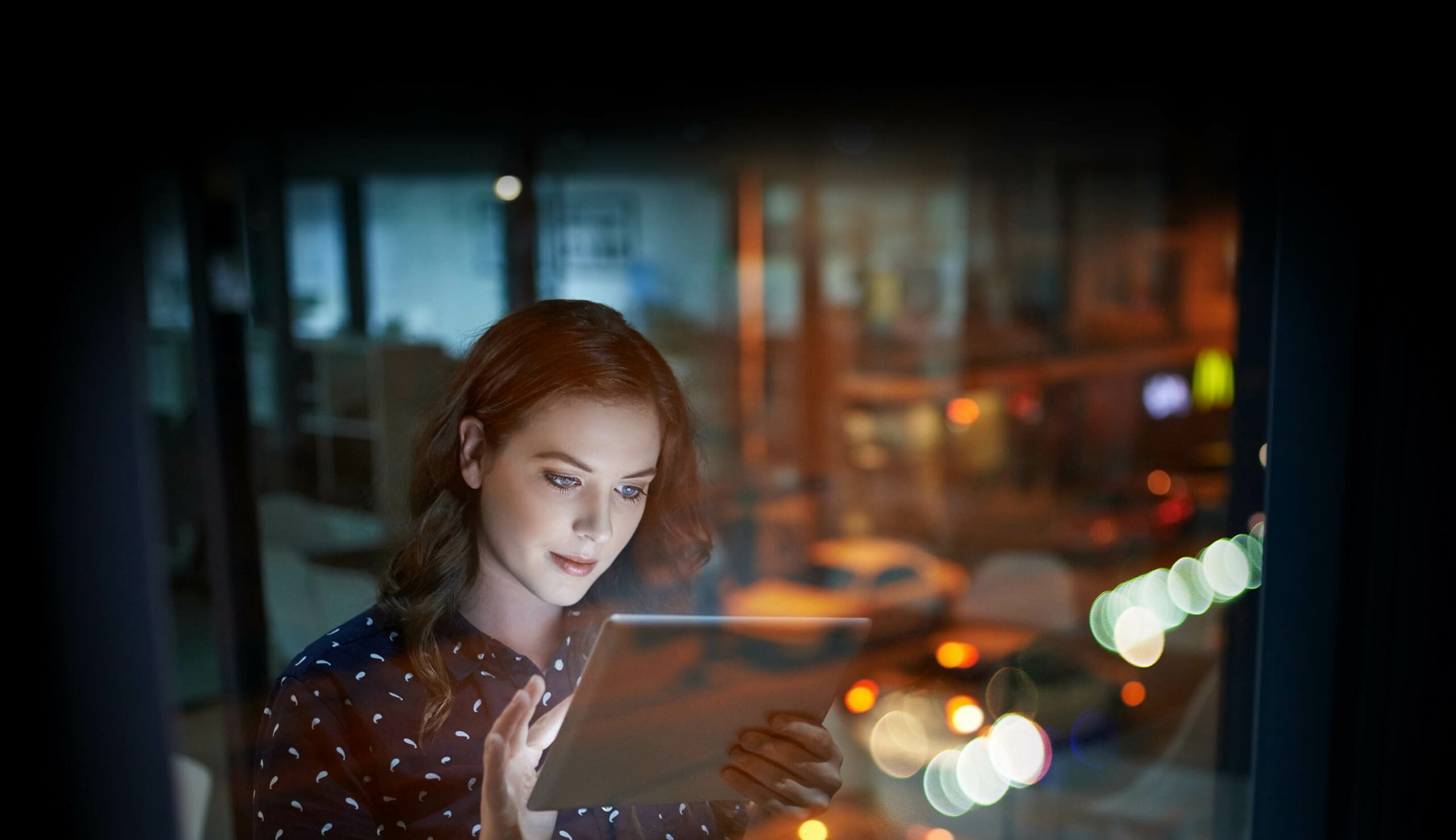 10 Reasons to Move to Business Central Blog Feature Image: A woman uses a tablet to check in on business data while sitting in her office