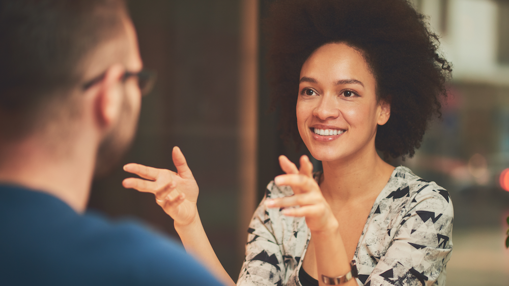 4 steps for Managers to Rock a Mid-Year Performance Review Meeting feature image: a black female manager conducts a performance review meeting with an employee