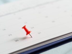 Month-End Closing Blog Feature Image: A red pin marks the last day of the month on a paper calendar