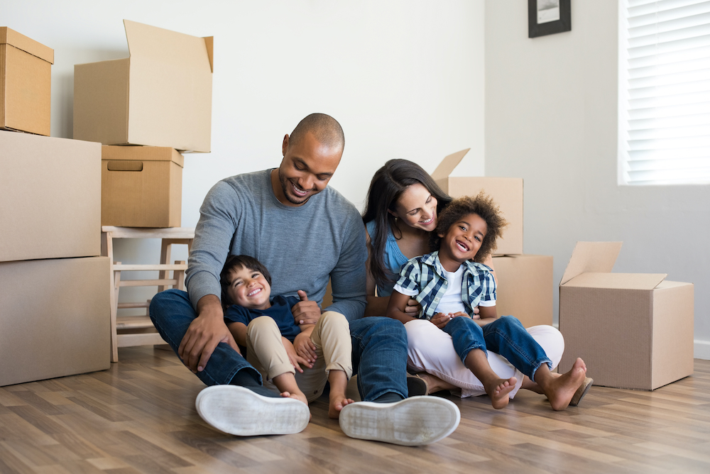 SharePoint Migration Best Practices 2 image: a family surrounded by moving boxes to represent the similarities to a SharePoint migration