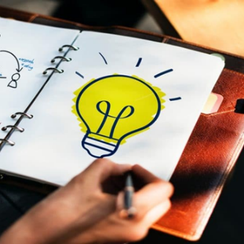 Ideation - the first step in setting up your microsoft 365 groups, person draws a lightbulb in a notebook