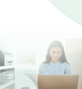 No Code / Low Code Application Modernization on Azure and Power Apps Header Image: A woman works happily on her computer in her office