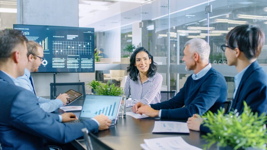 feature image: a CFO and their finance team sit in conference room reviewing data charts. Leveraging cloud integration and digital transformation in finance allows the team to work smarter.