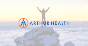 Photo of a person standing on a mountain top with the Arthur Health logo overlaid