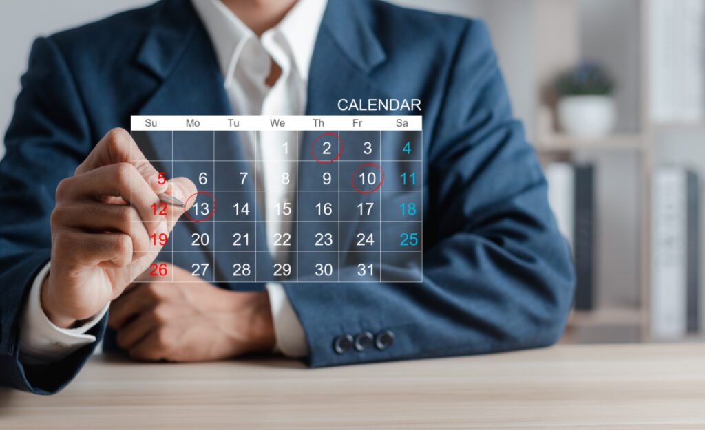 Man circling dates on a calendar.