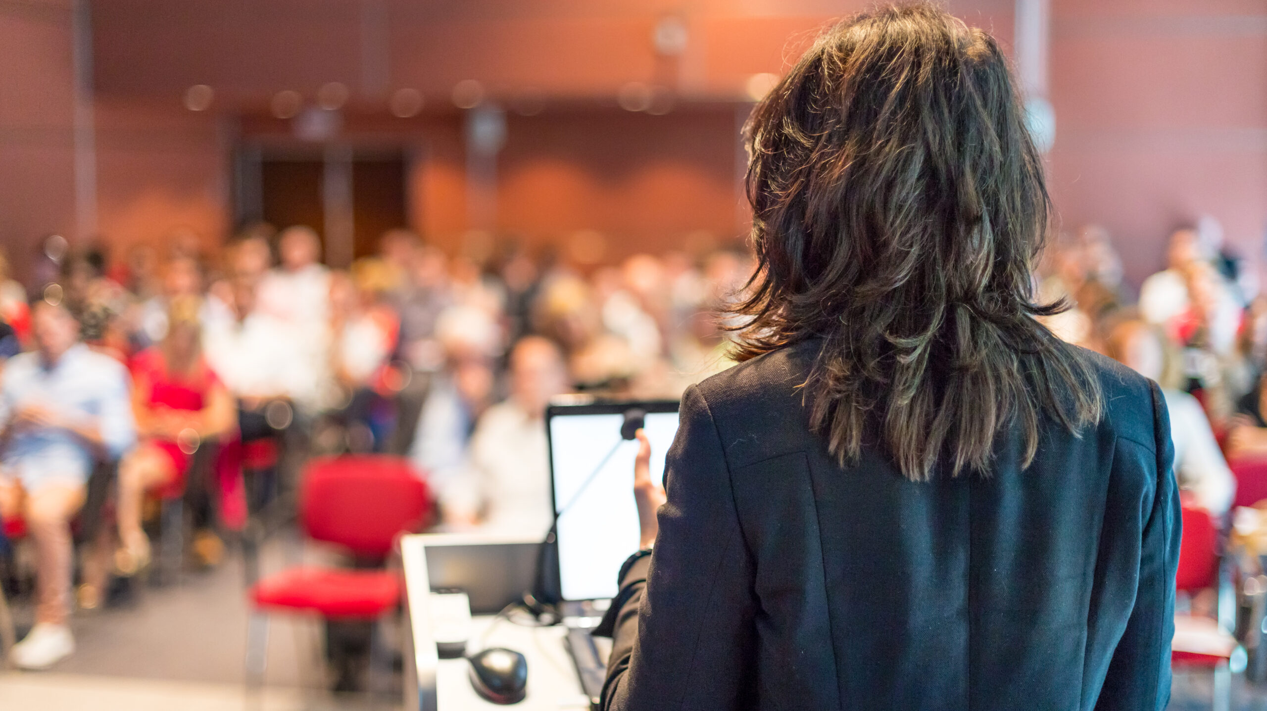 Power Apps in healthcare case study - Female Speaker Giving A Talk at a Corporate Business Conference