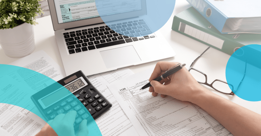 A person's hand over a desk littered with laptops with ERP tech on screen, calculators, and printed reports - Embracing Change During Periods of Cloud Transformation ERP Event Feature Image