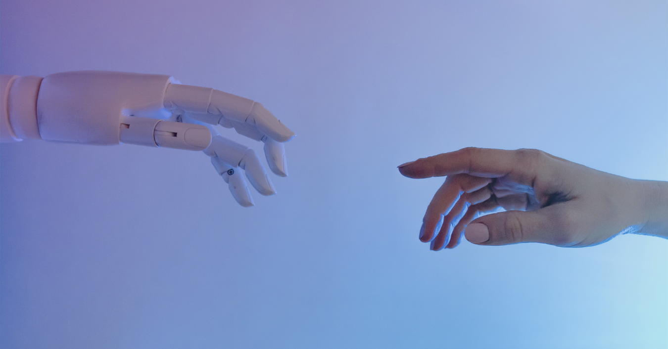 Prepare our Org for Safe AI Adoption - image of a robot hand about to touch a human hand to represent the changing times and the evolution of technology. Learn about the safe adoption of AI, secure AI, and responsible AI